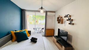 um quarto com uma cama e uma televisão num quarto em Les Appartements De Lina By LG Immo -Studio Abri-côtier - Self Check-In - em La Grande-Motte