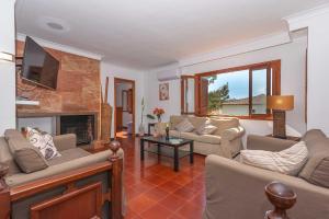 een woonkamer met 2 banken en een open haard bij Villa Francesca in Port d'Alcudia