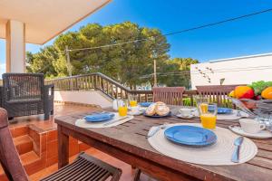 una mesa de madera con platos de comida en una terraza en Villa Francesca en Puerto de Alcúdia