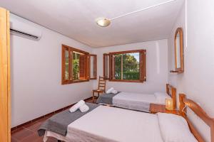 a room with two beds and two windows at Villa Francesca in Port d'Alcudia