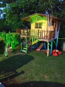 een speelhuis met een glijbaan in de tuin bij The Mouzakles Mansion in Metsovo