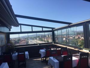 a restaurant with tables and chairs and a view of the city at RİVADA HOTEL in Kartepe