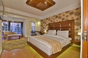 a bedroom with a large bed and a living room at Hillcrest Resort by DLS Hotels in Shimla