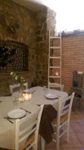 biały stół z białymi krzesłami i pokój ze ścianą z cegły w obiekcie Agriturismo San Leonardo w mieście Centola