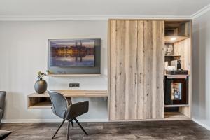 een kamer met een houten bureau en een stoel bij Parkhotel in Bad Waldsee