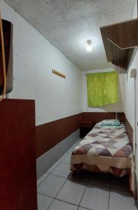 a bedroom with a bed and a green window at Hostal Venecia in Arica