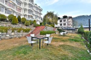 a table and chairs in front of a building at Hillcrest Resort by DLS Hotels in Shimla