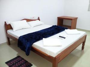 a bed with two pillows and a night stand on it at port Blair in Port Blair