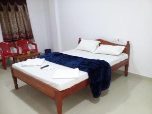 a bedroom with a bed with a blue blanket on it at port Blair in Port Blair