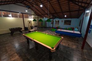 um quarto grande com uma mesa de bilhar e várias mesas em KINGMAKER'S Plantation with River Stream em Madikeri