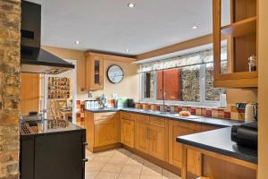 a kitchen with wooden cabinets and a black appliances at Finest Retreats - The Old School House in Instow