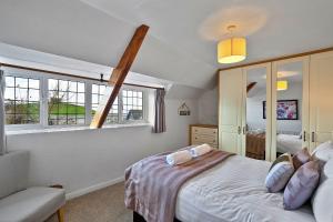 a bedroom with a bed and two windows at Finest Retreats - The Old School House in Instow