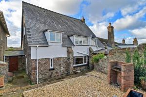 an old stone house with a stone wall at Finest Retreats - The Old School House in Instow