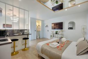 a white bedroom with a bed and a kitchen at Welcome to Dubai / Jacuzzi in Ivry-sur-Seine