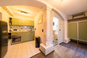 uma grande cozinha com armários verdes e uma coluna em Design Apartments - "Remise Blumberg" em Potsdam