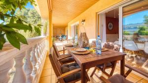 een veranda met een houten tafel en stoelen bij Costacabana - Villa Summertime in Lloret de Mar
