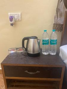 a tea kettle and two bottles of water on a table at Baga Beach Crystal in Baga