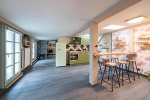 a kitchen with green appliances and a counter with stools at Design Apartments - "Remise Blumberg" in Potsdam