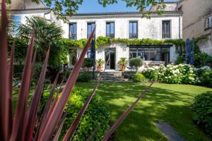 uma casa com um jardim em frente em Escale Rochelaise, chambre privé avec acces toute l'année au SPA chauffée et sauna em La Rochelle