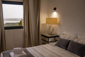 a bedroom with a bed with a window and a lamp at Made iN2 Creative Guest House in Montargil