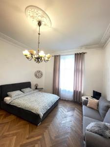 a bedroom with a bed and a chandelier at Great apartment Jana Kilińskiego 30 in Łódź