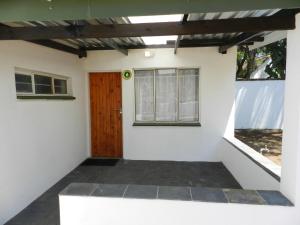 Habitación con puerta y ventana en President Paul Kruger Guest Lodge, en Rustenburg