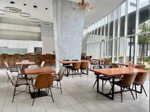 a cafeteria with wooden tables and chairs and windows at Mins to Johor Bahru Legoland Encorp Marina Puteri Harbour Sea View in Nusajaya