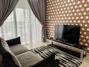 uma sala de estar com um sofá e uma televisão de ecrã plano em Mins to Johor Bahru Legoland Encorp Marina Puteri Harbour Sea View em Nusajaya