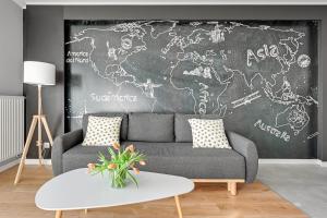a living room with a couch and a chalkboard at Apartamenty Apartinfo Centrum Władysławowo in Władysławowo