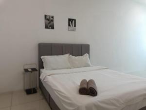 ein Bett mit zwei Paar Hausschuhen drauf in der Unterkunft Cozy 4 bedrooms House by Mr Homestay, 3 mins to Kulim Landmark Centre in Kulim