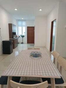 a dining room with a table and a kitchen at Cozy 4 bedrooms House by Mr Homestay, 3 mins to Kulim Landmark Centre in Kulim