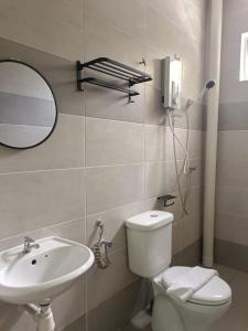 een badkamer met een wastafel, een toilet en een spiegel bij Cozy 4 bedrooms House by Mr Homestay, 3 mins to Kulim Landmark Centre in Kulim