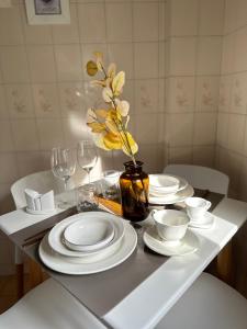 een tafel met witte borden en een vaas met gele bloemen bij Arena1 in Mar del Plata