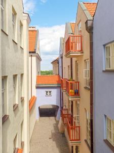 an alley between two buildings with orange balconies at Old Town Kanonia Apartments in Warsaw