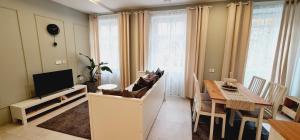 ein Wohnzimmer mit einem Esstisch und einem TV in der Unterkunft Cankar's Private Place in Ljubljana