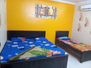 馬圖拉的住宿－RADHA MADHAV GUEST HOUSE，黄色墙壁客房的两张床