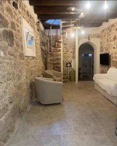 Apartmani Adi Tkon في تكون: غرفة نوم بسرير ودرج في جدار حجري