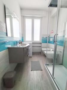 ein Badezimmer mit einem Waschbecken, einer Badewanne und einer Dusche in der Unterkunft My villa in the pinewood in Spotorno
