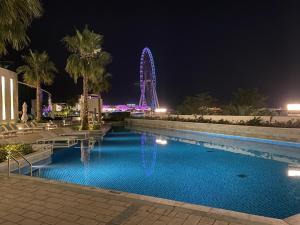 una piscina notturna con ruota panoramica di Address JBR with Sea View & Maid Room - Mint Stay a Dubai