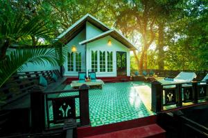 ein kleines Haus mit Kamin davor in der Unterkunft La La Land Resort Goa by Spicy Mango in Palolem