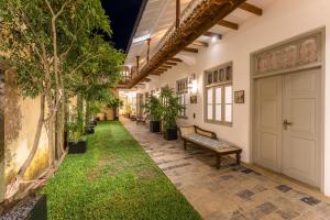 a hallway with plants and a bench in a building at The Fort House in Galle