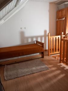 a room with a bed and a staircase with a rug at APARTMAN ZELENA DOLINA in Čajetina