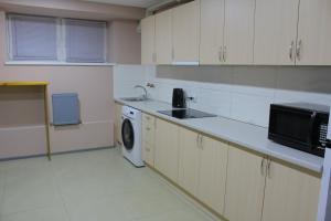 uma cozinha com um lavatório e uma máquina de lavar roupa em Uneed Rooms Petropavlivska em Kiev