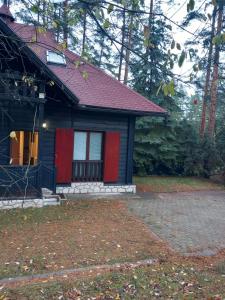 a small house with a red and black at APARTMAN ZELENA DOLINA in Čajetina