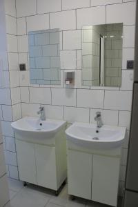 uma casa de banho com 2 lavatórios e um espelho em Uneed Rooms Petropavlivska em Kiev