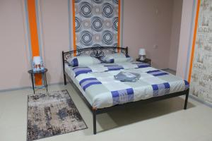 uma cama com um edredão azul e branco num quarto em Uneed Rooms Petropavlivska em Kiev