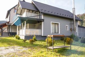 une maison avec une terrasse couverte et une balançoire dans l'établissement Ankamy Sweet Home, à Vorokhta