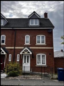 a red brick house with a white door at Charming 3-Bed House in Gloucester in Gloucester