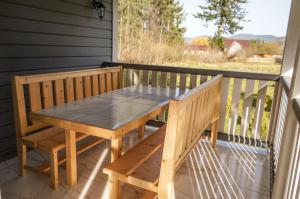 - une table et un banc en bois sur une terrasse couverte dans l'établissement Ankamy Sweet Home, à Vorokhta