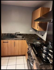 a kitchen with a stove top and wooden cabinets at Charming 3-Bed House in Gloucester in Gloucester